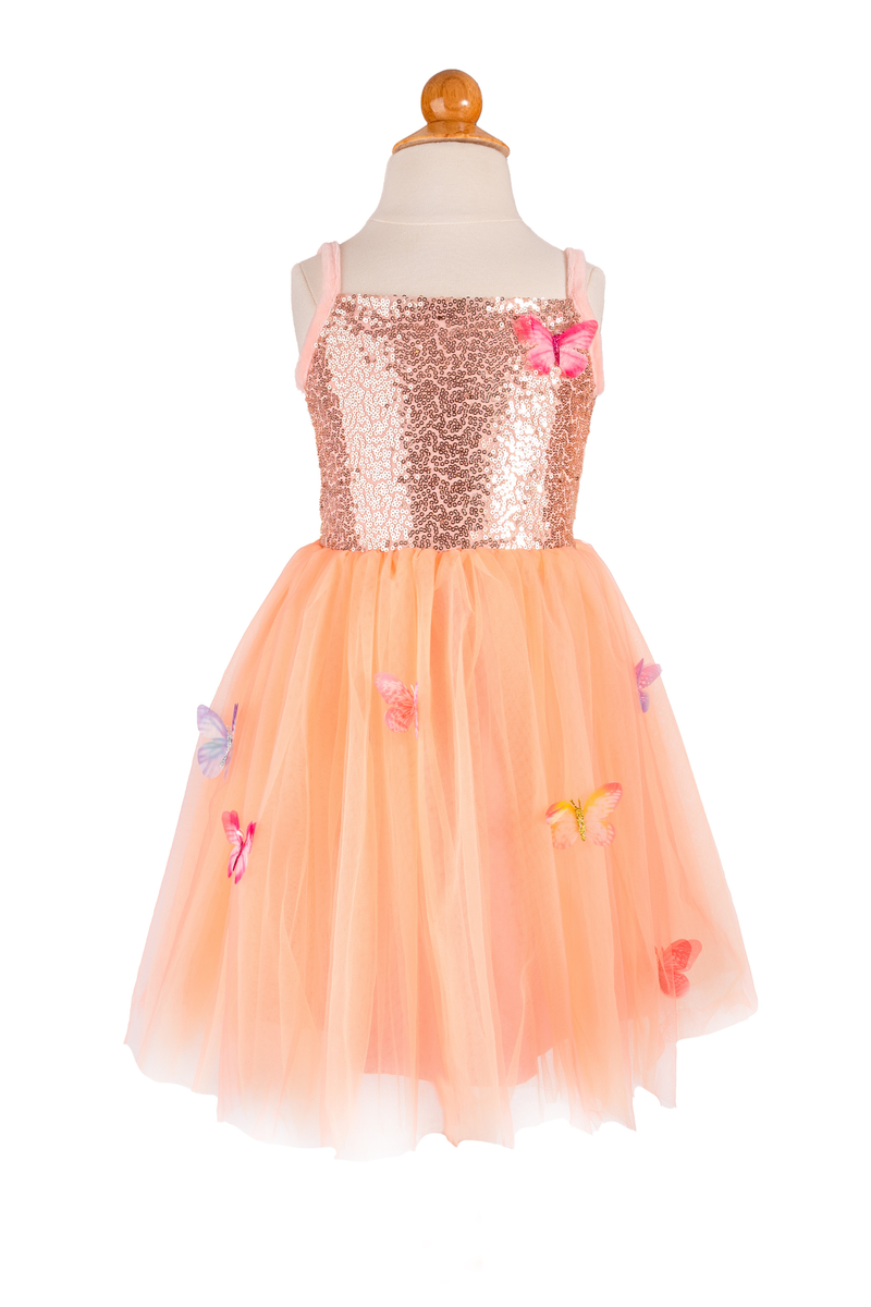 Peach sequin dress with floral embellishments on a mannequin against a white background